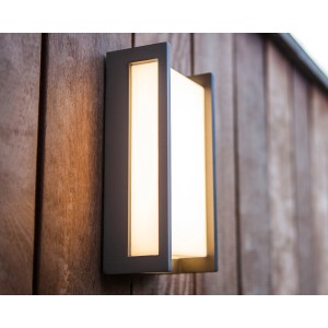 Moderne Lutec LED-Außenwandleuchte Qubo mit warmweißem Licht an Holzwand.