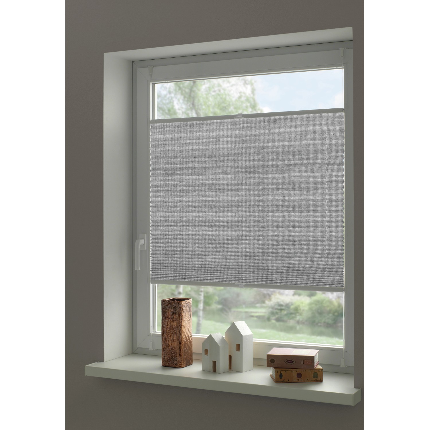 Graues Gardinia Plissee Concept am Fenster, blickdicht und einfach zu montieren.