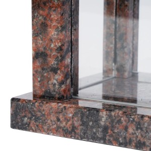 Detail der KOKA Grablampe Aurora. Polierter, rotbrauner Granit mit schwarzen Sprenkeln und klarem Glas. Robust, witterungsbeständig für Grabkerzen.