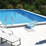 Summer Fun Styropor-Pool Set Lugano, eingebaut im Garten mit Leiter und Liegen auf der Poolterrasse.
