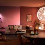 Philips Hue E14 LED Lampe in Wohnraum-Szene mit farbiger Beleuchtung.