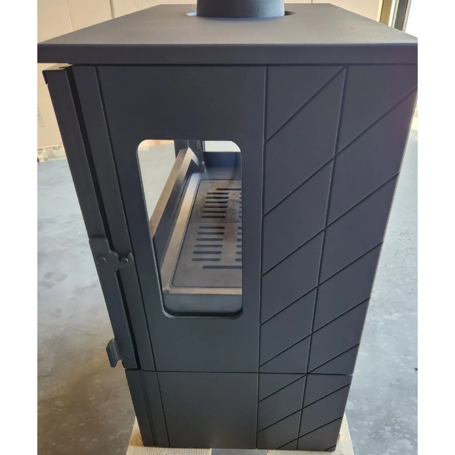 Plamen Gusskaminofen ECO 50, 12 kW, Detailansicht: Schwarzer Kaminofen mit Sichtscheibe und Gussmuster.