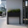 Hoher schwarzer Metall-Blumenkübel JAN NOWAK MARGARET H mit Pflanzen auf moderner Terrasse.