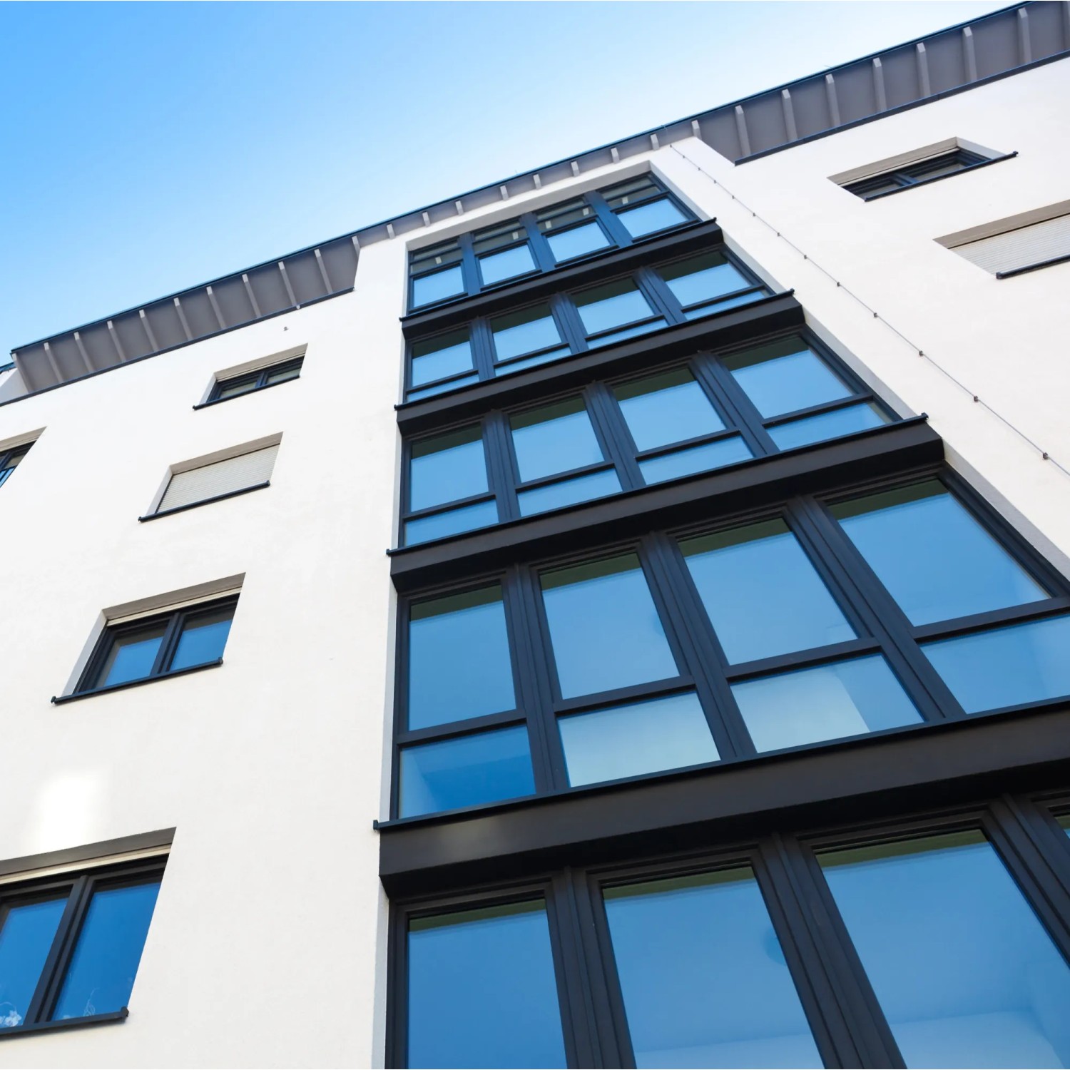 Gebäude mit Fenstern, die mit Venilia Tönungs-Fensterfolie beklebt sind.