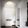 Weiße, runde Brilo LED-Deckenleuchte Walk mit warmem Licht an Decke im modernen Flur. Mit Bewegungsmelder und Dämmerungssensor.