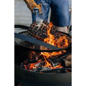CookKing Grillrost Stahl Ø 60cm mit Griff über Feuerstelle mit Grillgut.