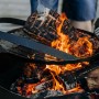 CookKing Grillrost Stahl Ø 60cm mit Griff über Feuerstelle mit Grillgut.