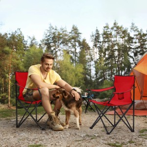 Blauer Sunula Campingstuhl mit Mann und Hund im Camp, Getränkehalter, Tragetasche.