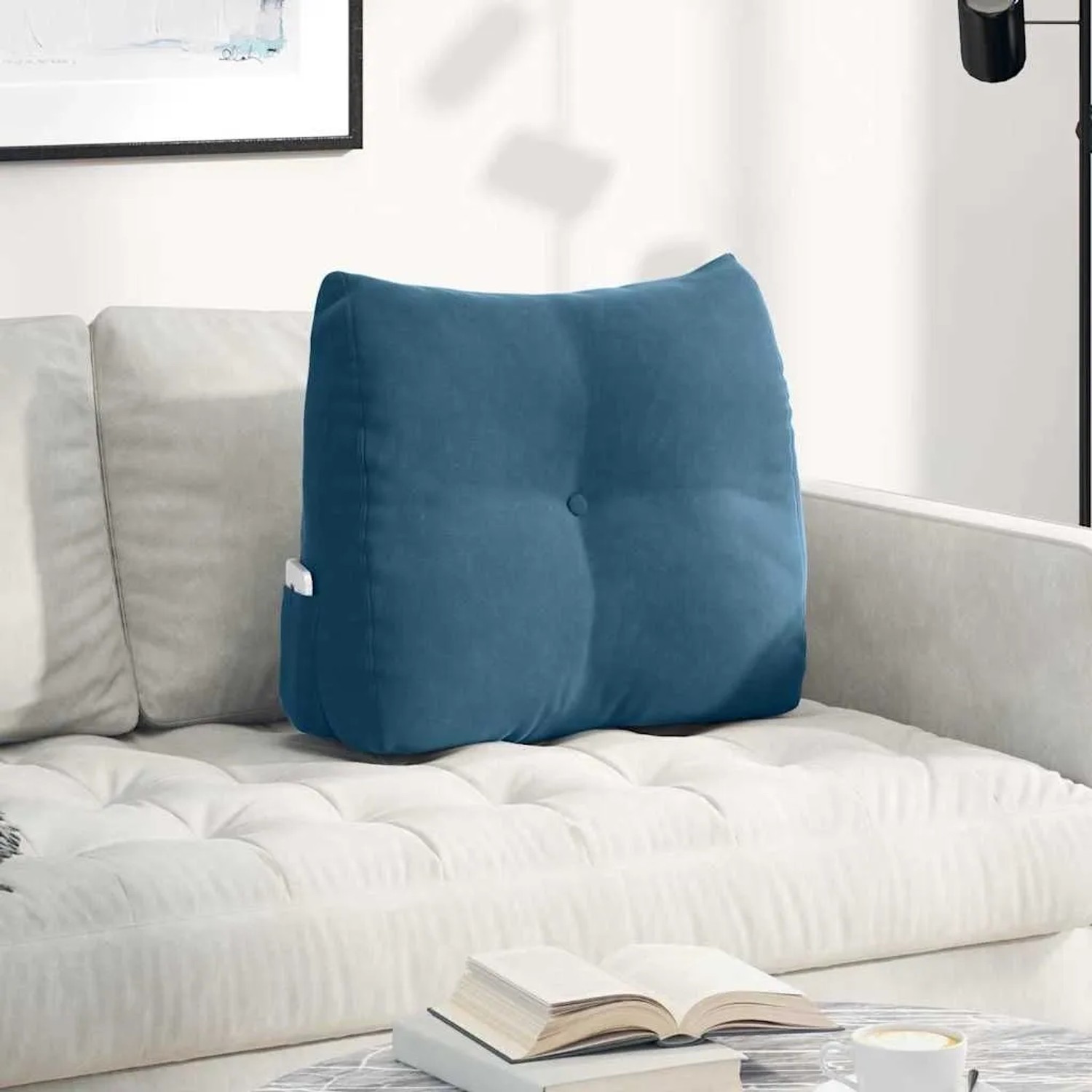 Blaues Samt-Rückenkissen mit Knopf und Seitentasche auf weißem Sofa. Ergonomisches Kissen 60x50 cm.