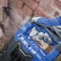 Detailaufnahme des blauen LUX-TOOLS Abbruchhammers E-ABH-1700 mit Hand am Griff.