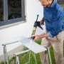 Mann nutzt wolfcraft Kartuschenpresse MG 600 Pro für Dichtstoff auf Fliese.