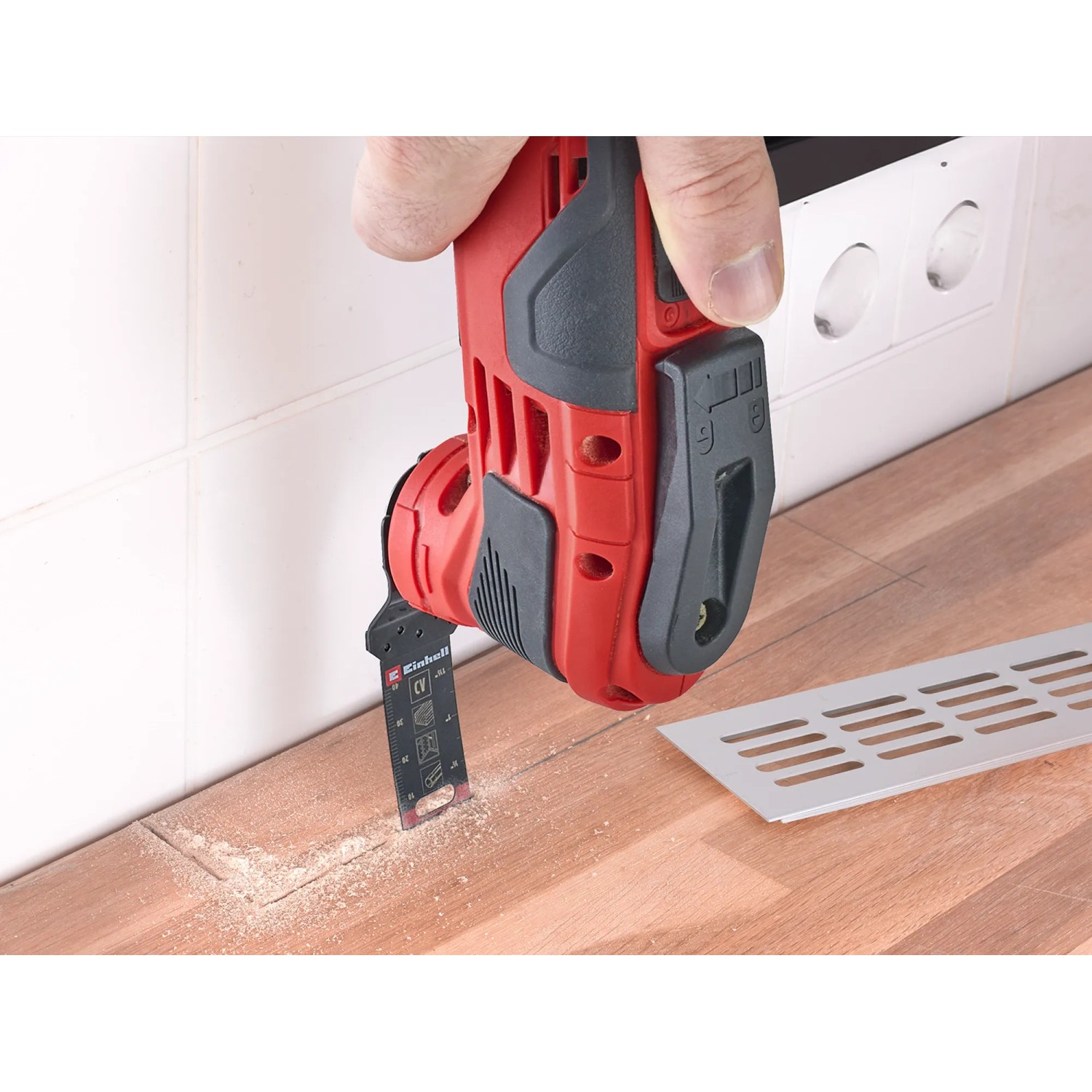 Einhell Multitool-Set XL: Rotes Multitool im Einsatz beim Sägen von Holz, 35-teilig.