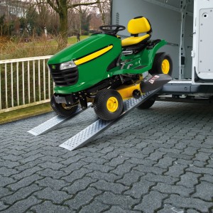 Zwei Aluminium Auffahrrampen mit Rasentraktor zum Verladen in einen Transporter.