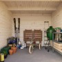 Hellbraunes Palmako Ella Holz-Gartenhaus mit Flachdach und Inneneinrichtung.