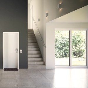 Weiße Wohnungseingangstür (links) im modernen Flur mit Treppe und Fenster.