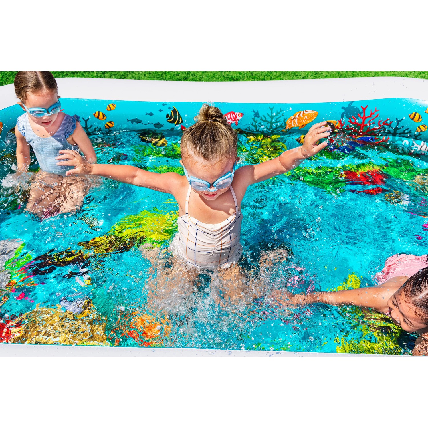 Kinder spielen im Bestway Family Pool 3D Undersea Adventure Planschbecken (262x175x51cm) mit Unterwasserwelt-Motiv.