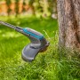 Gardena Akku-Rasentrimmer EasyTrim 25/18V Solo beim Trimmen von Gras an einem Baum.