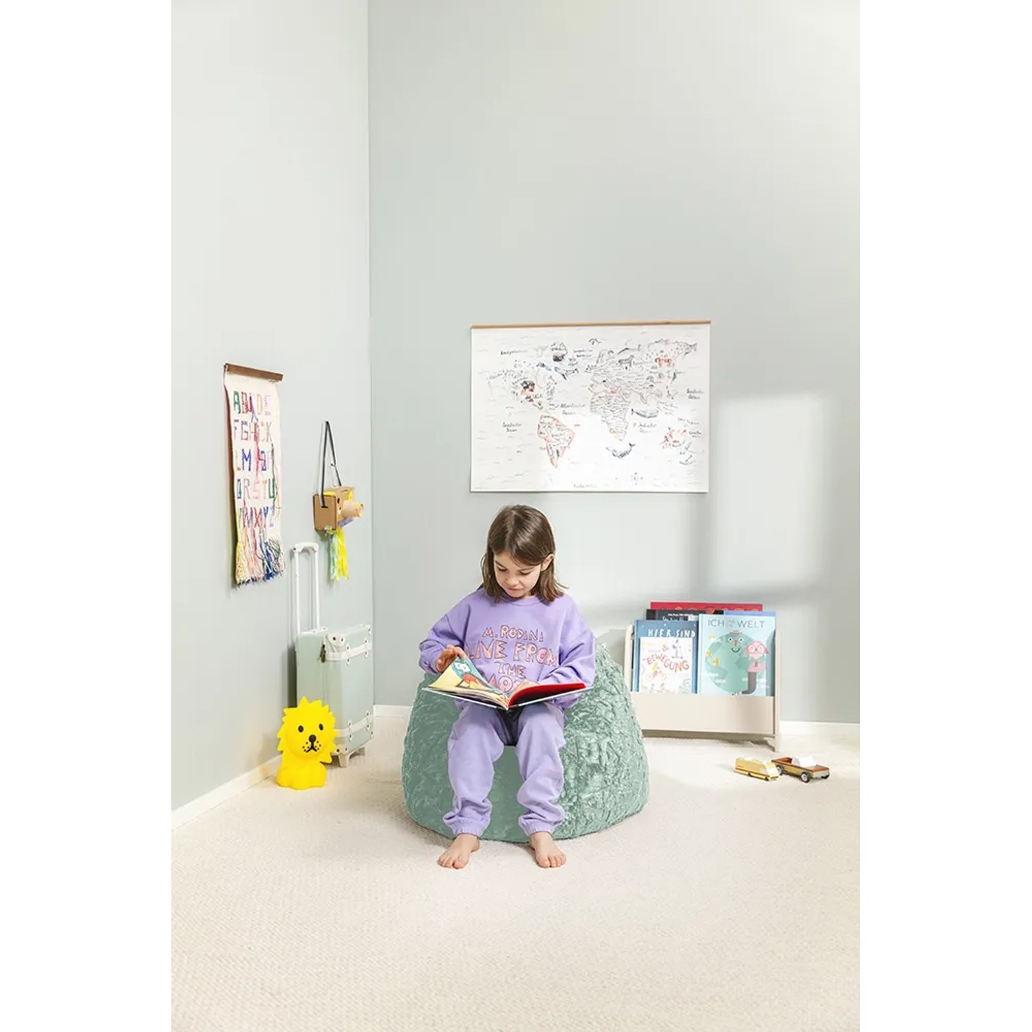 Mädchen liest auf Sitting Point Sitzsack Fluffy 120 l Salbei im Kinderzimmer.