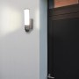 Moderne LUTEC LED-Kameraleuchte Elara Secury-Light neben einer Haustür. Smarte Aussenleuchte mit Kamera.