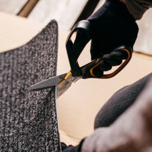 Fiskars PowerArc Hochleistungsschere schneidet Teppich, Handwerker mit Handschuhen