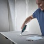 Mann sägt Gipskarton mit wolfcraft Handstichsäge, schwarzem 2-K-Griff. Ideal für präzise Ausschnitte im Trockenbau.