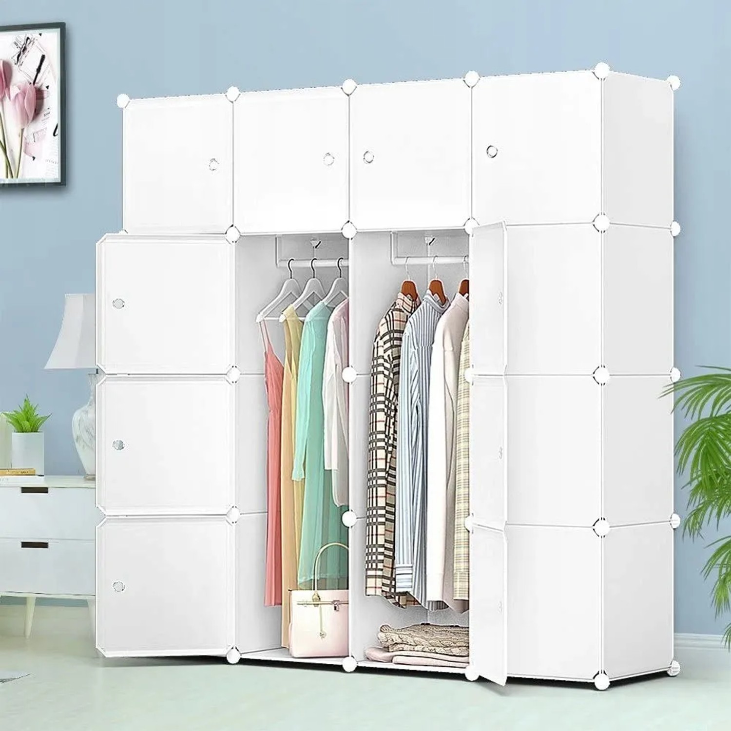 Weißer modularer Kleiderschrank mit vielen Fächern und Kleiderstangen, gefüllt mit bunter Kleidung. Geräumige, faltbare Garderobe.
