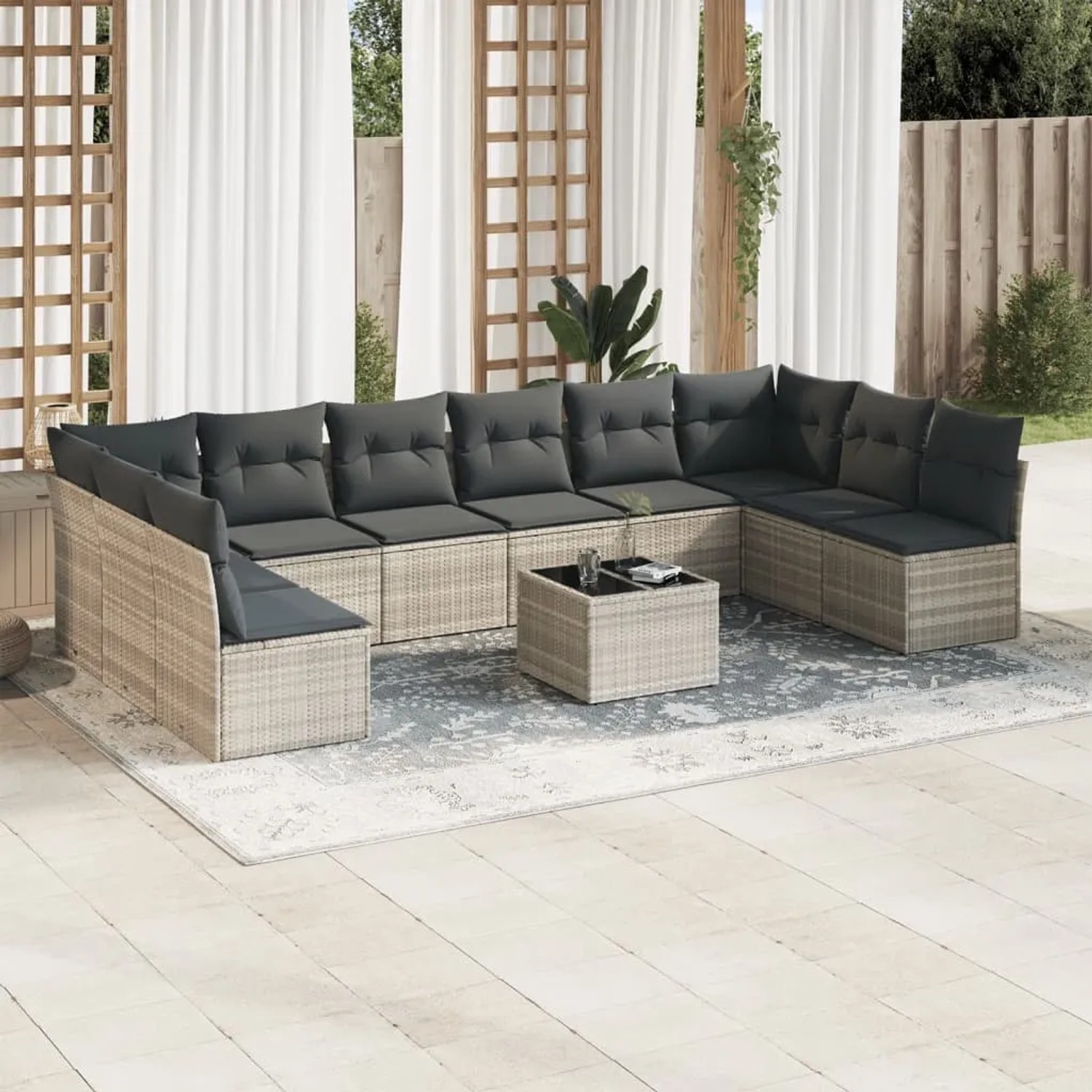 Hellgraue 11-tlg. Garten-Sofagarnitur aus Rattan mit dunklen Kissen und Tisch.
