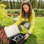 Frau öffnet Yard Force Werkzeugkoffer mit Gartenhandgeräten und Akku-Grasschere.