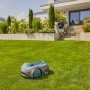 Gardena Mähroboter Sileno Smart Free 1200 auf Rasenfläche vor Haus. Kabelloser Rasenmäher.