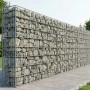 Rechteckige Gabione aus silbernem, feuerverzinktem Stahl, gefüllt mit grauen Steinen, als Sichtschutz im Garten.