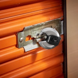 Master Lock Excell M40EURD Disc-Vorhängeschloss aus Stahl an einem orangefarbenen Rolltor.