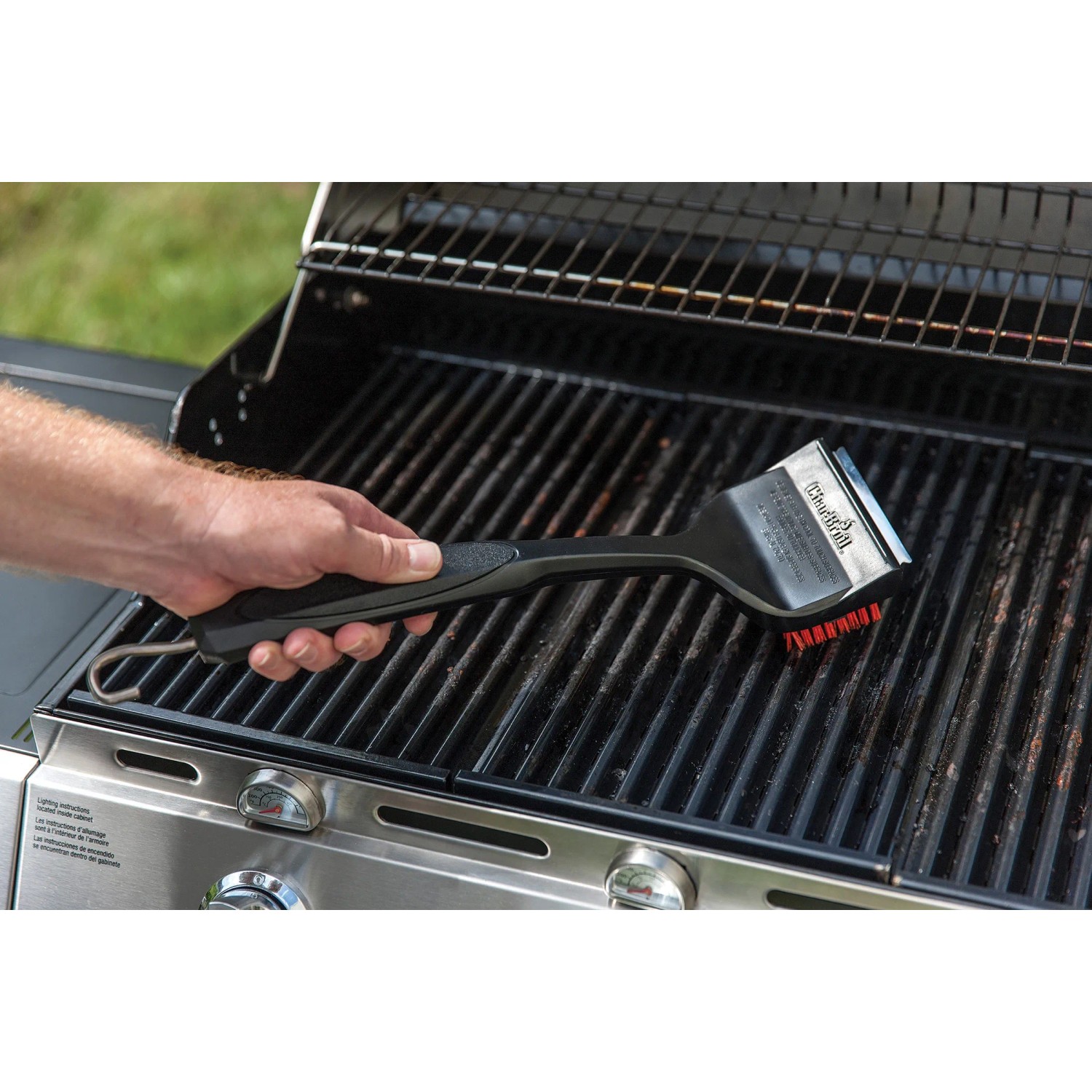 Char-Broil Grillbürste Cool Clean Premium in Aktion auf Grillrost. Grillutensil mit Schaber und Haken.