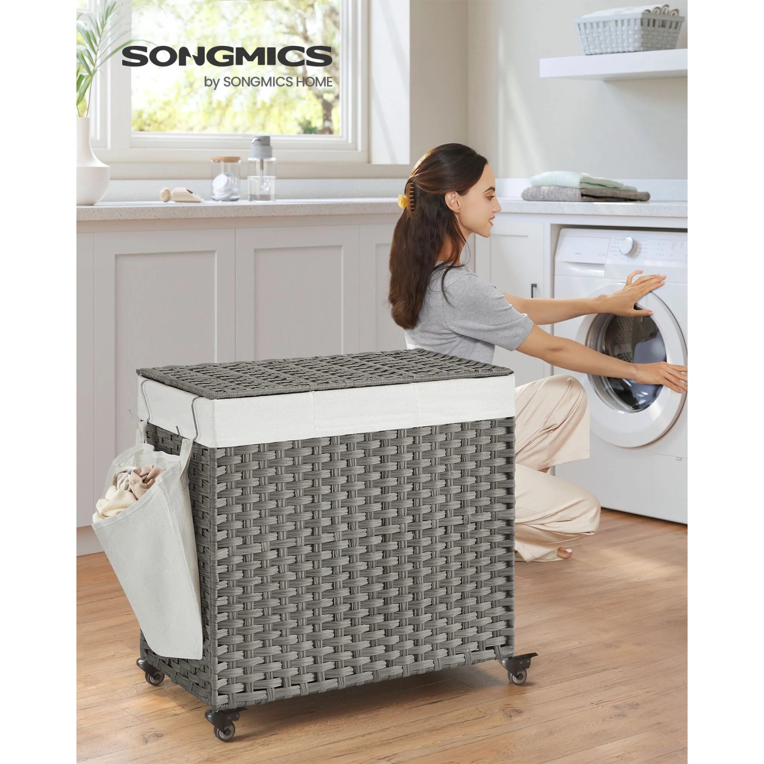 Grauer Songmics Wäschekorb mit Deckel, 140 l, mit Rollen und Seitentasche im Badezimmer.