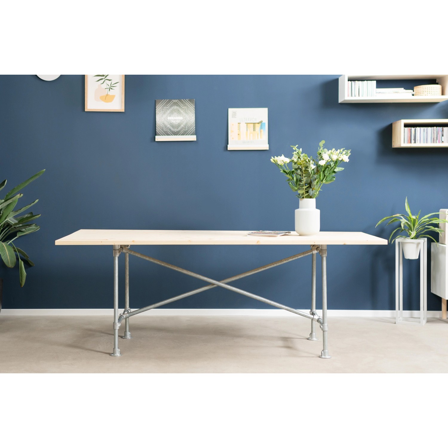 DIY-Tisch mit silberner, verzinkter Fußplatte und Stahlrohr-Gestell im modernen Wohnraum.