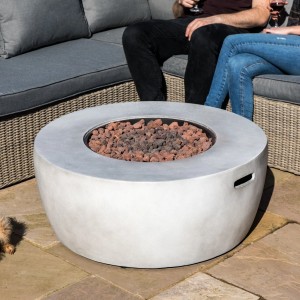Runde graue Gas-Feuerstelle aus Betonoptik mit Lavasteinen auf Terrasse. Für Propan-Betrieb im Garten.