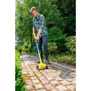 Mann benutzt Gloria Elektro-Unkrautfugenbürste WeedBrush zur Fugenreinigung im Garten.
