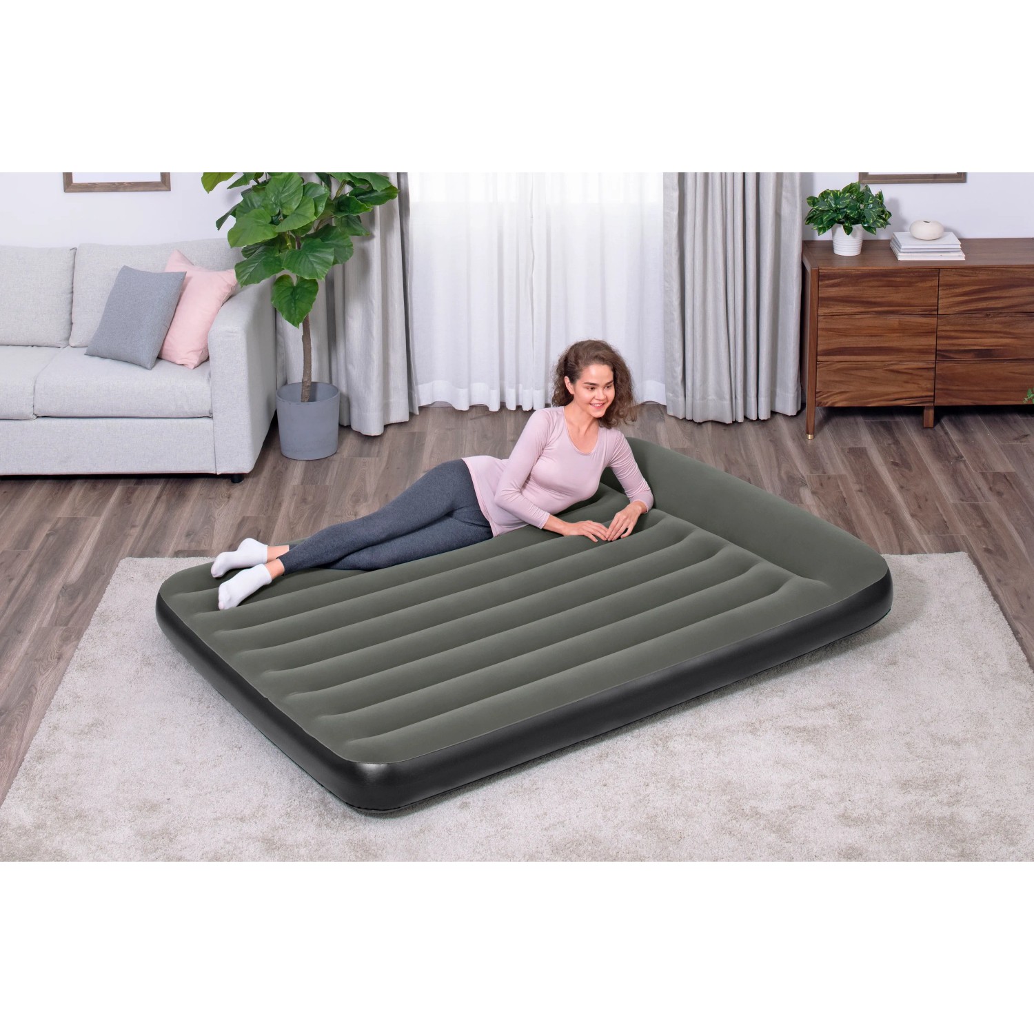 Bestway Doppelluftbett TriTech, 203x152x30 cm, schwarz, mit liegender Person im Wohnraum.