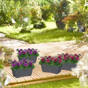 Relaxdays Blumenkasten Set, 4 anthrazitfarbene Kunststoff Pflanzkästen mit bunten Blumen auf einer Holzterrasse.