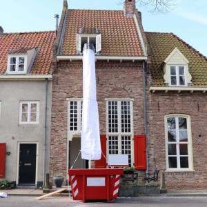Weiße flexible Schuttrutsche von Dachfenster in roten Container. 12 M Bauschuttrutsche mit Einfülltrichter für Abbruch.