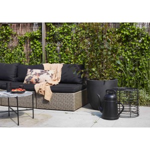 Schwarze Xala Gießkanne (12 l) neben Pflanzkübel im Garten.