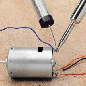 Löten mit LUX Lötkolben-Set (60 W) an einem Elektromotor mit Lötzinn und Kabeln.