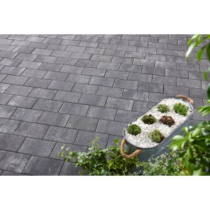 Verlegtes Betonpflaster Vero in Anthrazit-Grau, nuanciert, mit Pflanzgefäß. Ideal für Terrasse & Garten.