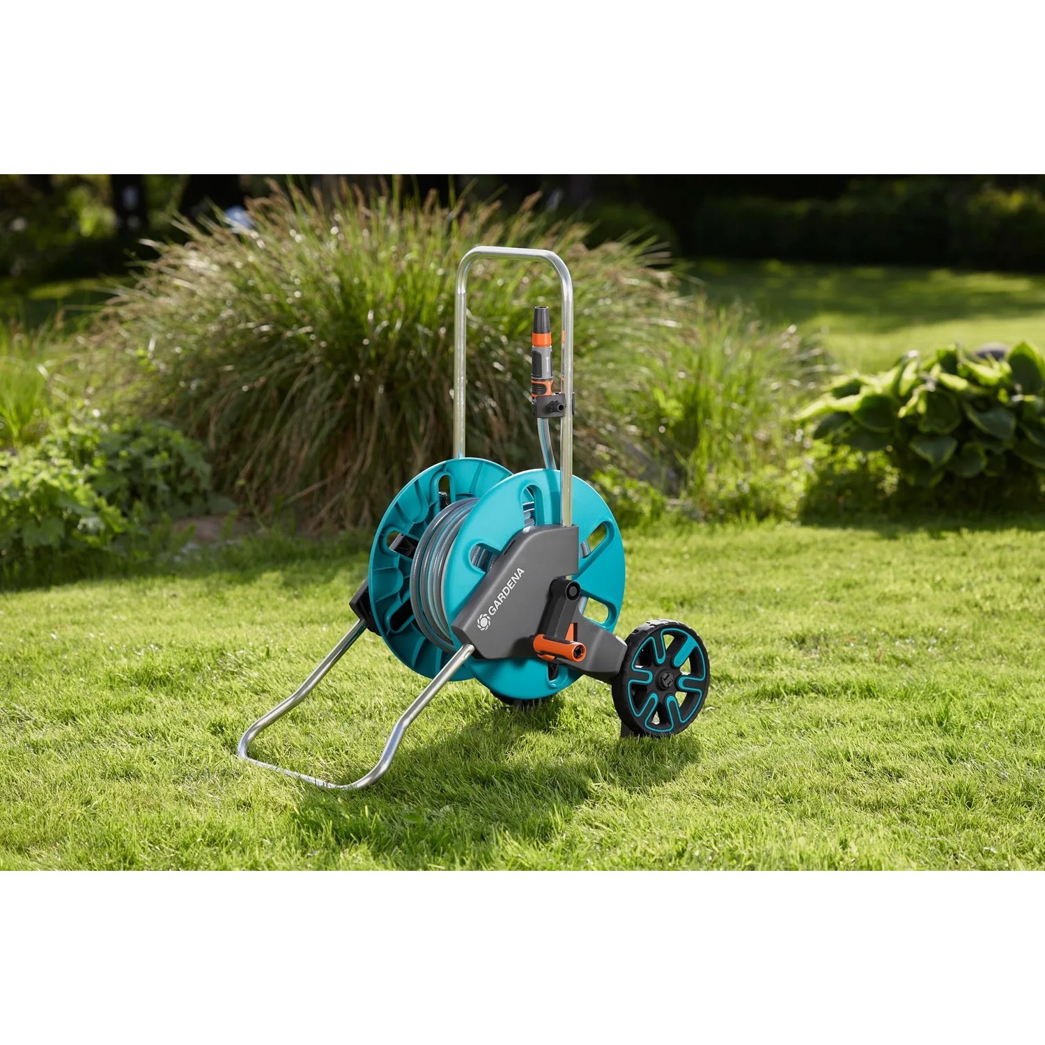 Gardena Schlauchwagen CleverRoll M mit 20 m Schlauch auf Rasen. Gartenschlauchwagen-Set mit Spritze.