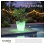 Weißer LED-Leuchtzylinder mit Pflanze, grün leuchtend, am Pool. Ideal als Blumentopf oder Sektkühler für Garten & Terrasse.