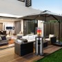 Schwarzer Juskys Gasheizer Cuna auf Terrasse mit Gartenmöbeln und Sonnenschirm.