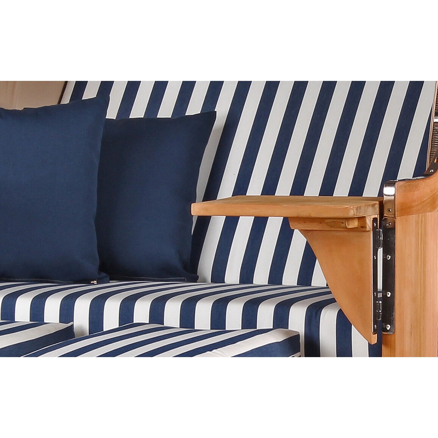 Detailansicht: Grauer Strandkorb Schaalsee Teak mit blau-weiß gestreiften Kissen und Holztisch.