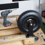 Schwarze luftbereifte Schwerlast-Bockrolle aus Stahl und Gummi auf Palette mit Werkzeug. Für Transportwagen.