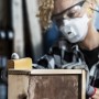Frau schleift Holz mit Bosch Expert Schleifblatt C470 K240. Schleifmittel für feine Oberflächen.