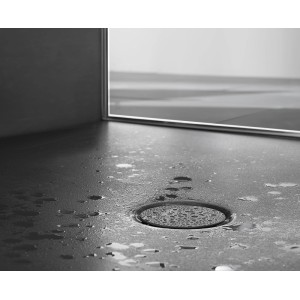 Detailaufnahme: Matte, anthrazitfarbene Bette Duschwanne Stage 120x100 mit Wasser und Ablauf.