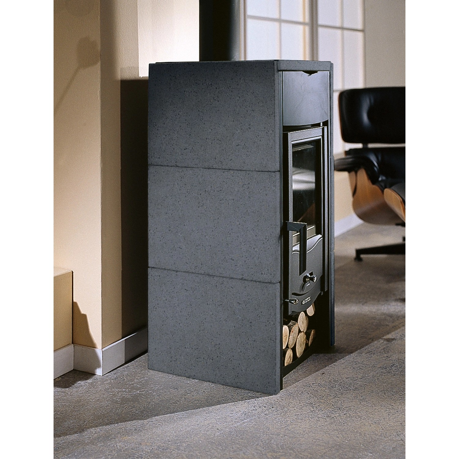 La Nordica Asia Bii Kaminofen mit Natursteinverkleidung und Holzscheiten.